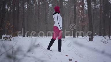 在冬季森林里散步的非裔美国女孩。 穿着白色保暖夹克的漂亮女孩独自度过时光。 概念
